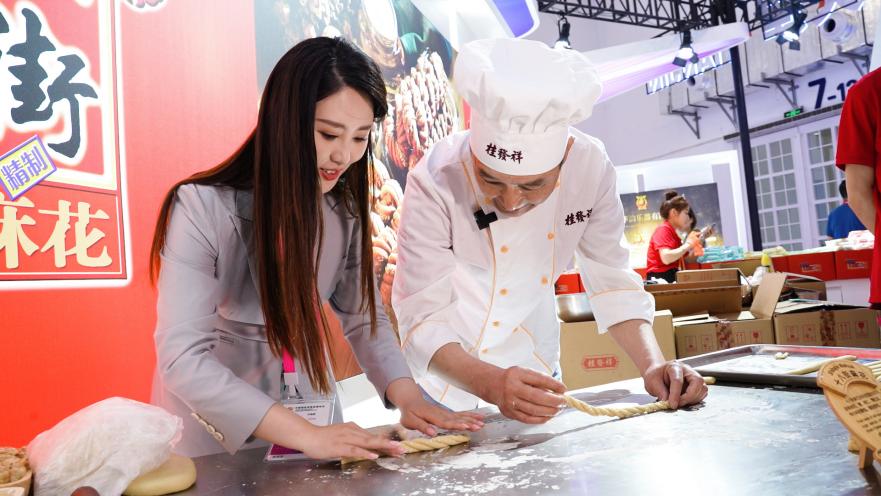 今年4月，在2023年中国国际消费品博览会现场，记者体验中华“老字号”传统美食的制作工艺。记者 张力洋摄